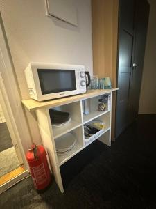 Ein TV und eine Mikrowelle auf dem Tisch in einem Zimmer in der Unterkunft Center apartments in Oslo