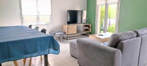 uma sala de estar com uma mesa e uma televisão em Appartement calme, à proximité du parc des expos em Quimper