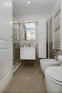 a bathroom with a toilet and a sink and a tub at Ludovisi Barberini Grand Apartment in Rome