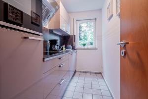 eine kleine Küche mit einem Waschbecken und einem Fenster in der Unterkunft City Park Apartments - #11-12 - Apartments mit Ambiente am Park in Leipzig