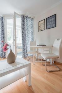 a white living room with a table and chairs at City Park Apartments - #11-12 - Apartments mit Ambiente am Park in Leipzig