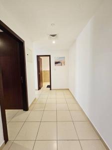 um corredor vazio com uma porta e um piso de azulejo em Luxury JBR Apartment 24 em Dubai