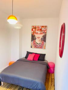 1 dormitorio con 1 cama con una pintura en la pared en Appart 2 chambres HYPERCENTRE de Berck-Plage - WIFI en Berck-sur-Mer