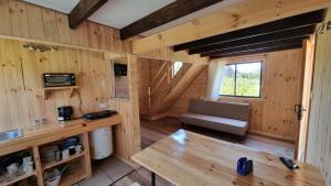 Cabaña de madera con sofá y ventana en Cabaña en Llifen, en Futrono