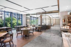 un restaurante con mesas, sillas y ventanas en Courtyard by Marriott Shenzhen Bao'an, en Bao'an