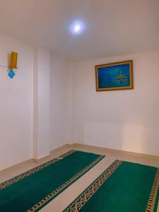um quarto com um tapete verde e uma fotografia na parede em Residence Tanjung Pakuan em Bogor