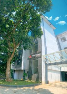 um edifício com uma árvore em frente em Residence Tanjung Pakuan em Bogor