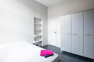 Un dormitorio con armarios blancos y una toalla rosa en una cama en Maison standing 9 chambres 5SB avec extérieur, en Roubaix