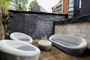 three wicker chairs and a table on a patio at Astrid by Oval in London