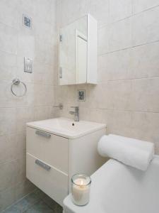 a bathroom with a sink and a toilet with a candle at Astrid by Oval in London