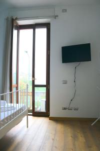 um quarto com uma cama e uma televisão na parede em Lovely Navigli Studio with balcony - Via Carlo torre em Milão