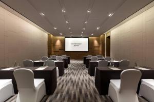 a conference room with tables and chairs and a screen at Courtyard by Marriott Changsha South in Changsha