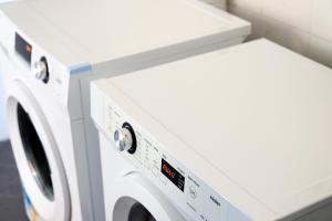 a washer and dryer in a laundry room at Baileys Parkside Motel by VetroBlu in Perth
