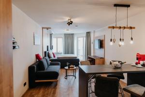 - un salon avec un canapé et une table dans l'établissement Alpenwolke Appartements, à Kempten