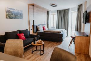 ein Wohnzimmer mit einem Sofa und einem Tisch in der Unterkunft Alpenwolke Appartements in Kempten