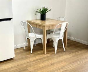 una mesa de madera con 2 sillas y una maceta en ella en Accommodation @ 134 Denham, en Townsville
