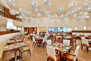 a restaurant with tables and chairs and chandeliers at Courtyard by Marriott Riyadh Olaya in Riyadh