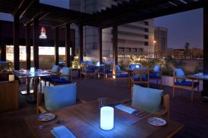 a restaurant with tables and chairs and a view of the city at Courtyard by Marriott Riyadh Olaya in Riyadh