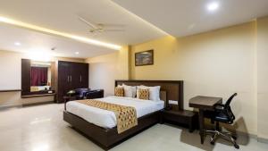 印多尔Monk's Nirvanaa Hotel & Resort的配有床和书桌的酒店房间