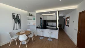 a kitchen and dining room with a table and chairs at C-10 Vegueta Apartment - Private Rooftop Pool in Las Palmas de Gran Canaria