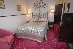 a hotel room with a bed and a couch at Stow Lodge Hotel in Stow on the Wold