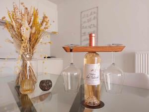 uma garrafa de vinho numa mesa com dois copos de vinho em Villa Creole 0308 Luxe appartement met verwarmd zwembad Nieuwpoort Jachthaven em Nieuwpoort