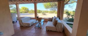 a porch with couches and chairs and a large window at Casa Italia Vivienda Turistica ET6132 in Es Caló