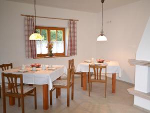 a dining room with white tables and chairs and a window at Holzhammer Hof in Bayerbach