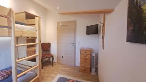 ein Zimmer mit einem Etagenbett und ein Schlafzimmer mit einem Stuhl in der Unterkunft Landhaus Brockhaus in Rettenberg