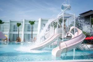 un tobogán de agua en una piscina con una fuente en The Gems Mining Pool Villas Pattaya en Nong Prue