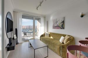a living room with a couch and a large window at Chlebova River View by Grand Apartments in Gdańsk