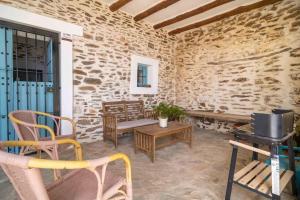 eine Terrasse mit Stühlen, einer Bank und einem Tisch in der Unterkunft Paraje la Suerte Cortijo la Suerte in Adra