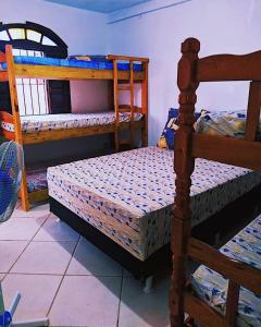 a bedroom with two bunk beds in a room at Hostel&Pousada Equilíbrio in Praia Grande