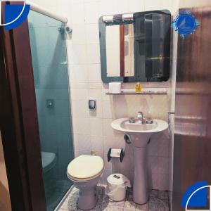 a bathroom with a sink and a toilet and a mirror at Hostel&Pousada Equilíbrio in Praia Grande