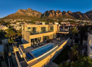 a house with a swimming pool and mountains in the background at 26OnFirst - UPS, Sea Views and Personalised Services in Cape Town