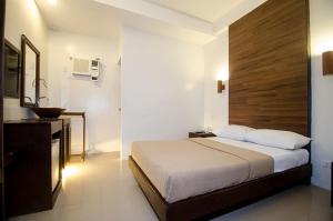 sypialnia z dużym łóżkiem i umywalką w obiekcie Taj Guesthouse Boracay w mieście Boracay