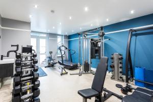 une salle de sport avec des murs bleus et des tapis de course dans l'établissement Kensington Rooms - Warwick Road, à Londres