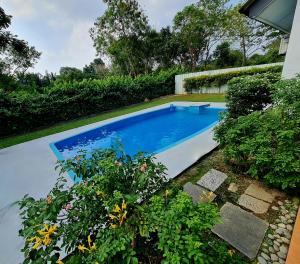 Kampong Alor GajahにあるPrivate 4Bedroom Villa Pool,BBQ,Karaoke, Afamosa Resortの植物のある庭のスイミングプール