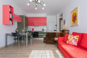 a living room with a red couch and a kitchen at Saluzzo House by Wonderful Italy in Turin