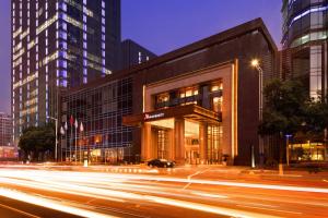 a building on a city street with cars in front of it at Changzhou Marriott Hotel in Changzhou