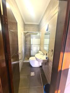 La salle de bains est pourvue de toilettes, d'un lavabo et d'une douche. dans l'établissement Zoom Chalets, à Amman