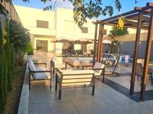 a patio with wooden tables and chairs and anophe at Zoom Chalets in Amman