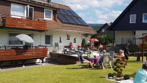 a group of people sitting in the yard of a house at Haus Nietmann_ Ferienwohnung 4 in Altenau