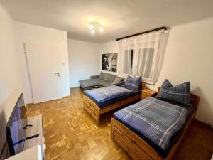ein Wohnzimmer mit 2 Betten und einem Sofa in der Unterkunft Wohnung Nähe LKH und der Med Uni in Graz