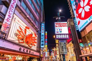 a busy city street at night with neon signs at Apartment Hotel 11 Shinsaibashi II in Osaka
