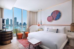 um quarto com uma cama branca e uma grande janela em W Dubai - Mina Seyahi, Adults Only em Dubai