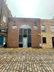 a brick building with a door in the middle at Modern self-contained Ground and Basement studios in London