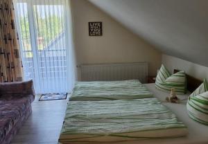 a bedroom with two beds and a couch at Gästehaus Nietmann_ Ferienwohnung 6 in Altenau