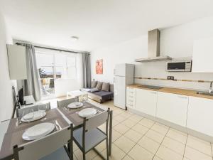a kitchen and living room with a table and chairs at Matorral Beach Apartament beautiful ocean view in Morro del Jable