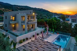 ハニア・タウンにあるChris villa with private ecologic pool and kid's playground!のスイミングプールと夕日を望むヴィラ